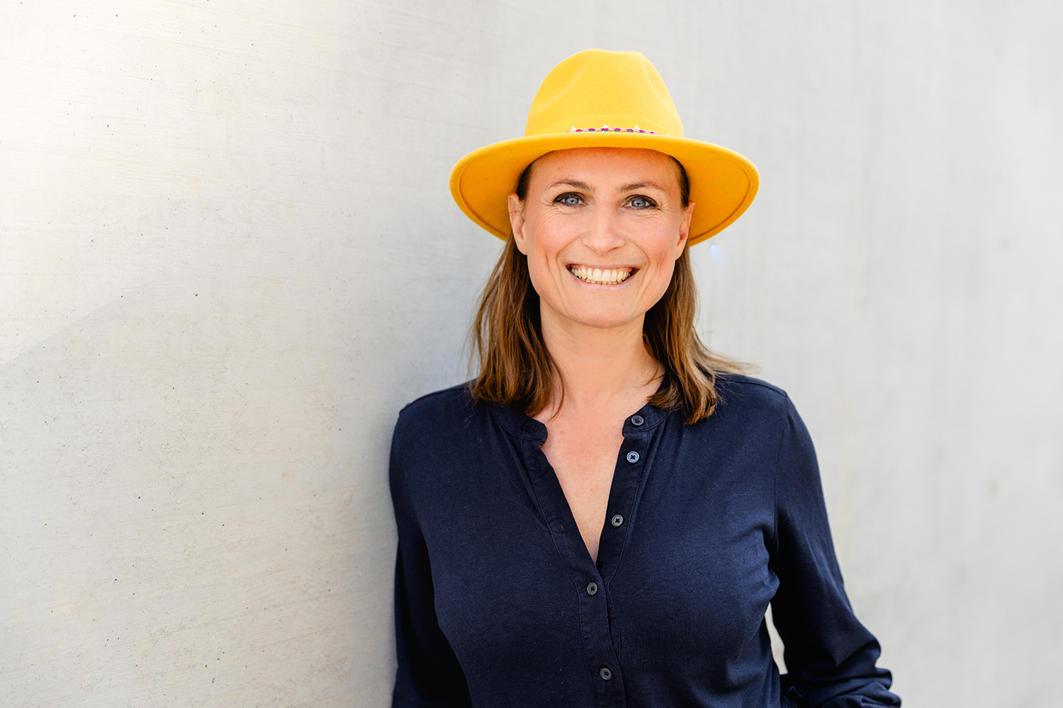 Bossin-Stuttgart-Olga-Gerashchenko_web korallfarbener text page and photo coming soon in einem gelben Kreis auf hellgrauem Hintergrund